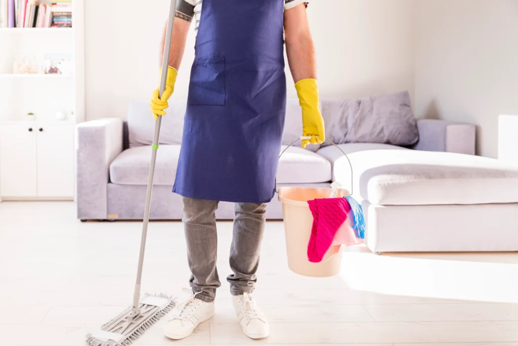 Professional cleaner mopping floor in living room